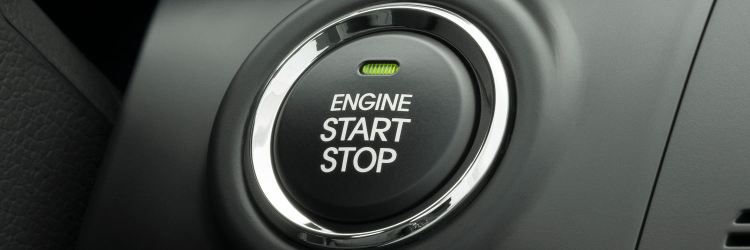 close up of a engine start stop button with green indicator light